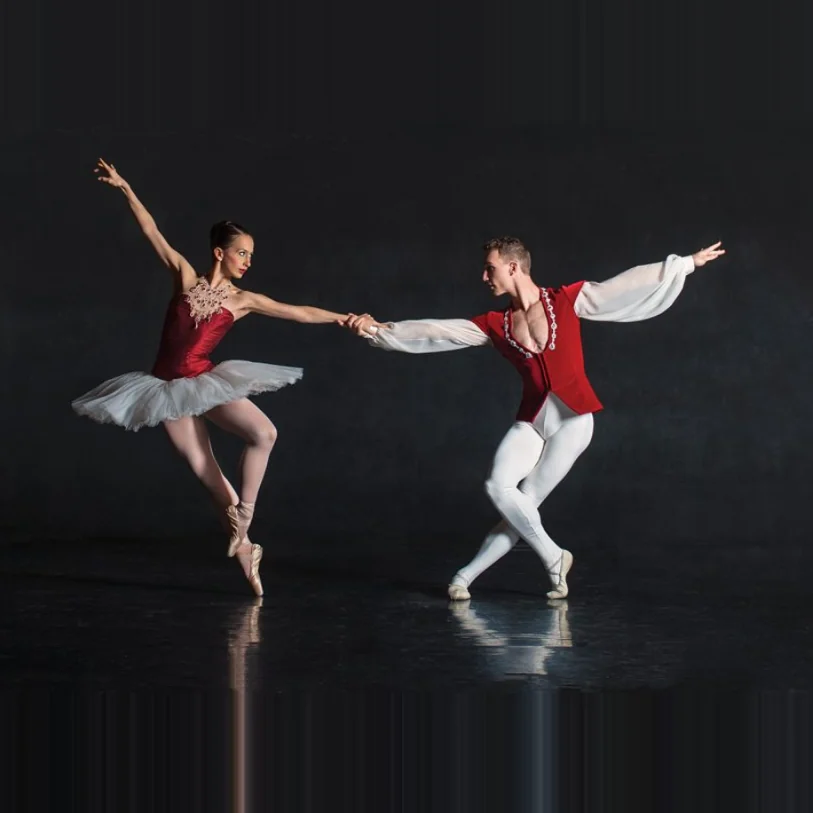 Ballet duo performing a partnered pose on stage