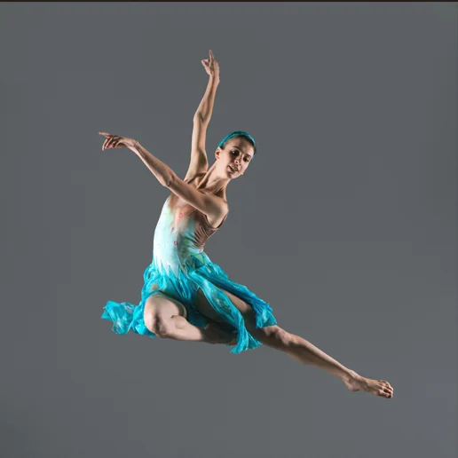 Modern dancer leaping in a teal costume